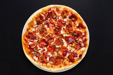 Siyah arka planda lezzetli bir pizza.