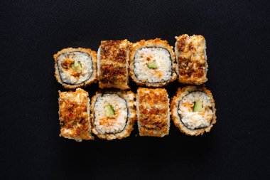 Siyah arkaplanda suşi var.