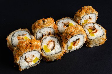 Siyah arkaplanda suşi var.