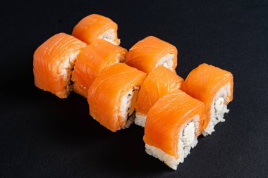 Siyah arkaplanda suşi var.