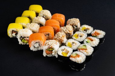 Siyah arkaplanda suşi var.