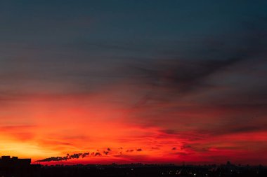 Büyük şehrin üzerinde turuncu gün batımı