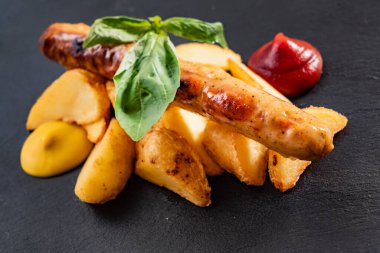 Siyah arka planda sebzeli sosis.