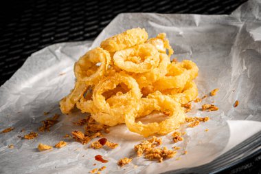 Lezzetli altın hırpalanmış, ekmekli ve kızarmış soğan halkaları.