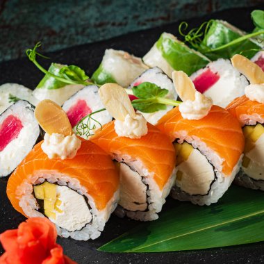 Siyah arkaplanda suşi var.