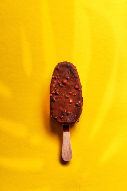 Sarı arka planda çikolatalı dondurma.
