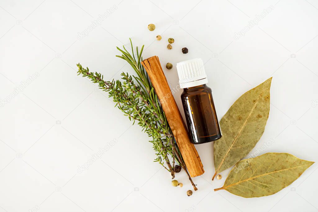 Bottle of essential oil with herbs and spices