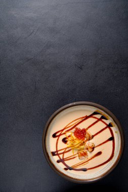 Siyah arka planda mantar kremalı çorba.