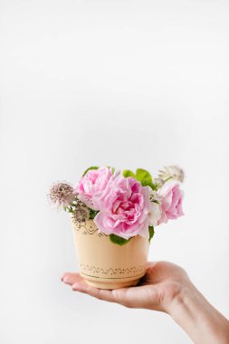 Fincanda güzel çiçekleri olan bir kadın.