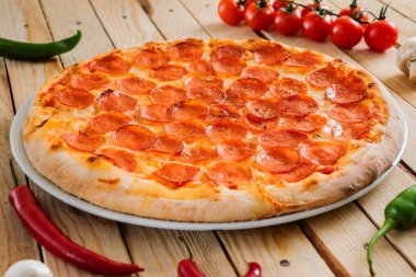Ahşap arka planda taze pişmiş pepperoni pizza.