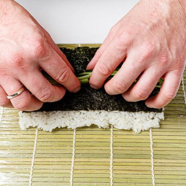 chef making japanese sushi on mat