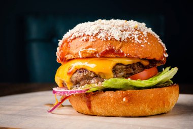 Batı usulü pastırmalı hamburger, soğan halkaları ve bbq sosu.