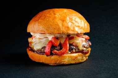 Siyah arka planda lezzetli bir burger.