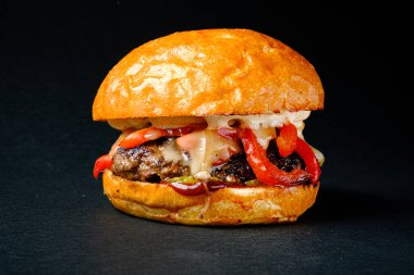 Siyah arka planda lezzetli bir burger.