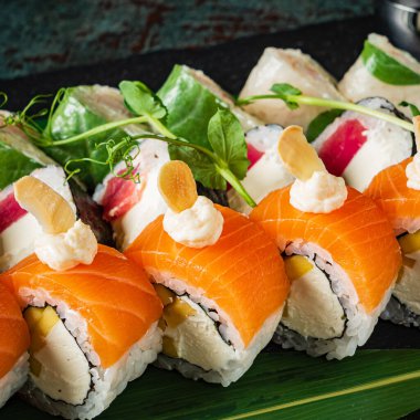 Siyah arkaplanda suşi var.