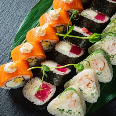 Siyah arkaplanda suşi var.