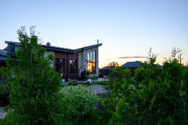 Yeşillikleri ve kaldırımlı gevşek plakası olan yeşil bir bahçe.