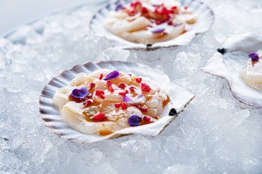 Taş tahtadaki istiridyelerin tazeliği. Tazelik için istiridye kabuğu açtım. İki yarı açık kabuklu limon ve limonlu siyah taş zemin.