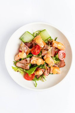 Beyaz arka planda deniz ürünleri salatası.