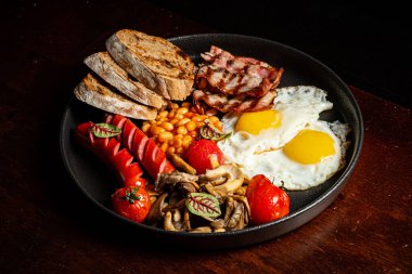 Pastırmalı İngiliz kahvaltısı, sosis, kızarmış yumurta, fırında fasulye.