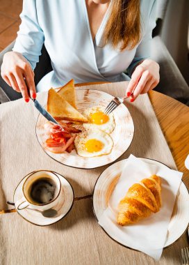 Kafede geleneksel kahvaltı yapan bir kadın.