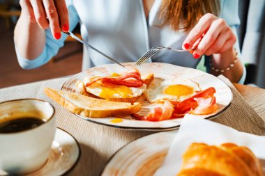 Kafede geleneksel kahvaltı yapan bir kadın.
