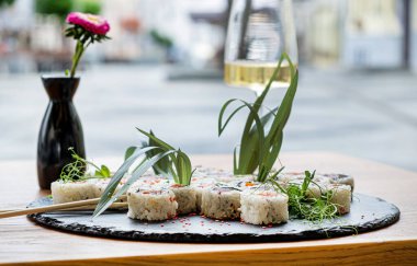 Suşi ve beyaz şarap restoranda.