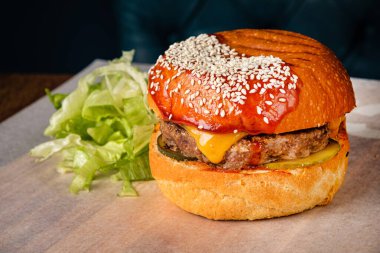 Batı usulü pastırmalı hamburger, soğan halkaları ve bbq sosu.