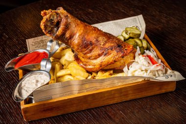 Geleneksel gurme Alman atıştırmalığı kızarmış patates, kızarmış sebzeli ızgara domuz kaburgası, ızgara panelinde bıçak ve bira..