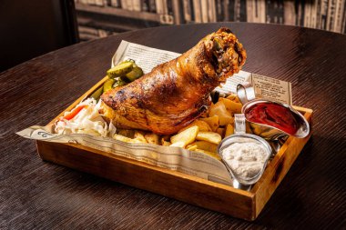 Geleneksel gurme Alman atıştırmalığı kızarmış patates, kızarmış sebzeli ızgara domuz kaburgası, ızgara panelinde bıçak ve bira..