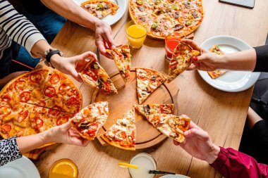 Bir grup insan pizza yemek. 