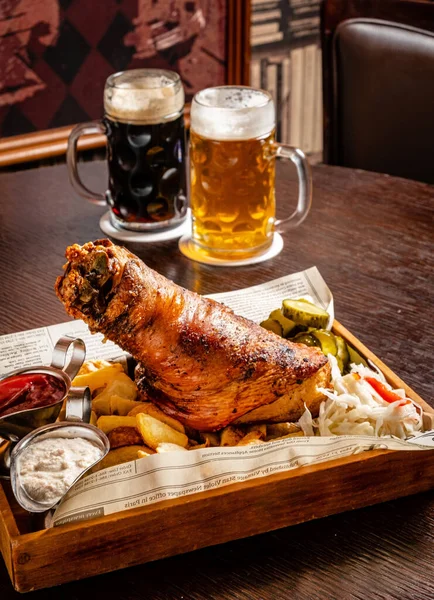 传统的德国风味小吃 烤土豆 烤猪排和炸蔬菜 鸡腿和啤酒放在烤架上的锅里 — 图库照片