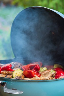 Mangal ızgarasında ızgara sebze ve tavuk sosisi.