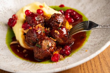 Patates püresi ve kızılcık soslu biftek köftesi.