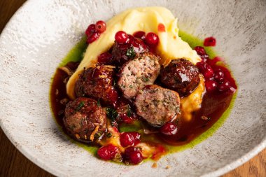 Patates püresi ve kızılcık soslu biftek köftesi.