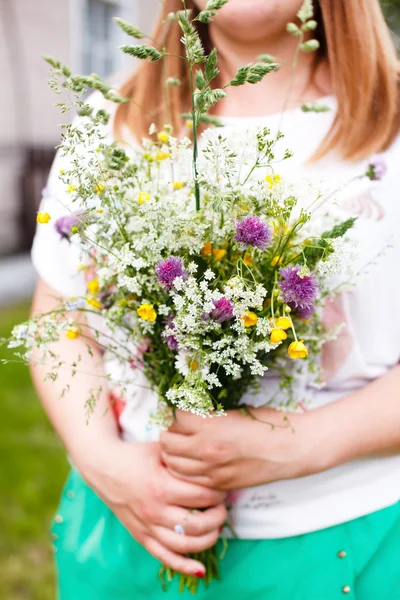 Kvinna anläggning vilda blommor — Stockfoto