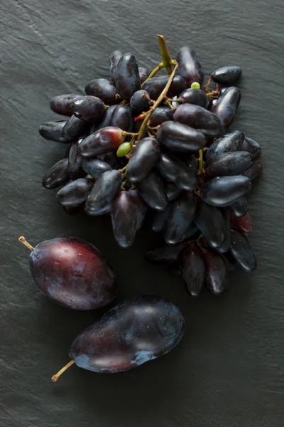 Синий виноград со сливами — стоковое фото
