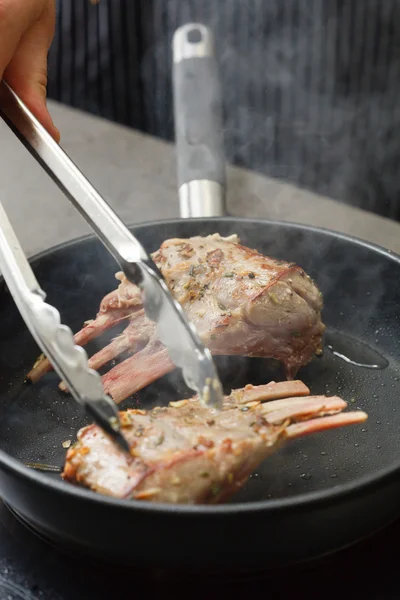 Man frituren lamb chops op pan — Stockfoto