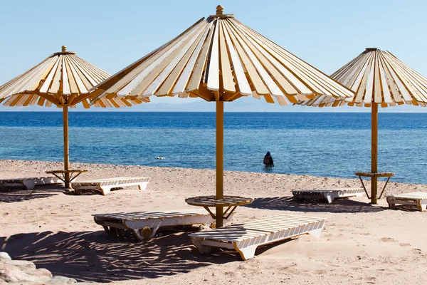 Umbrellas over chaise longues — Stock Photo, Image