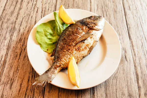 Roasted fish on plate — Stock Photo, Image