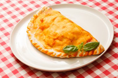 Calzone pizza on white plate clipart