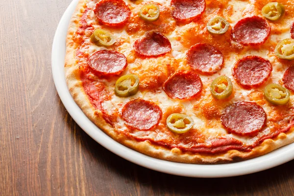 Pizza de pepperoni na mesa de madeira — Fotografia de Stock