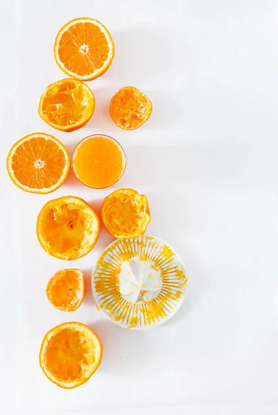 Espremedor de mãos, sumo e laranjas — Fotografia de Stock