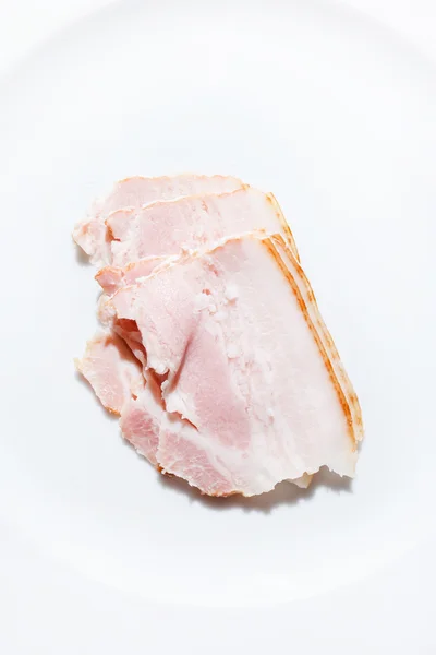 Skivor av bacon på vit — Stockfoto