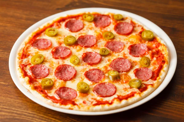 Pizza auf Holzboden — Stockfoto