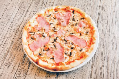 Tahta arka planda pizza.