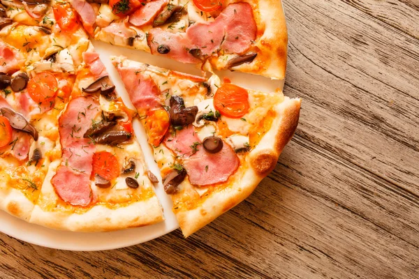 Піца на дерев'яному фоні — стокове фото