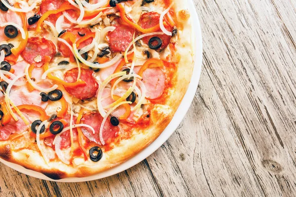 Pizza on wooden background — Stock Photo, Image