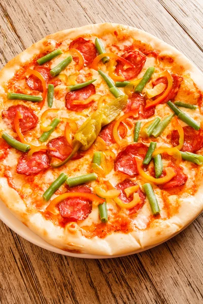 Pizza on wooden background — Stock Photo, Image