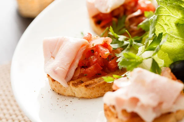 Bruschetta with tomato and ham — Stock Photo, Image